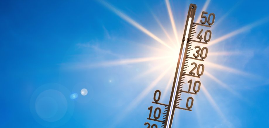 Summer background, bright sun with thermometer