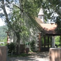 Trauerhalle am Friedhof im Ortsteil Eidengesäß, umgeben von Bäumen. Im Vordergrund ist der Eingangsbereich zum Friedhof zu erkennen.