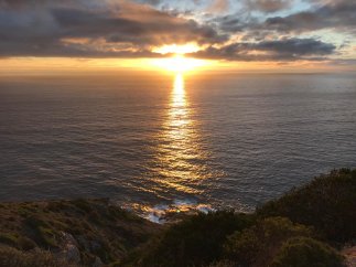 Sonnenuntergang über dem Meer Sonnenuntergang über dem Meer mit Uferböschung im Vordergrund