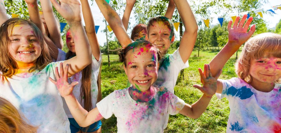 Portrait of bright kids smeared in colored powder
