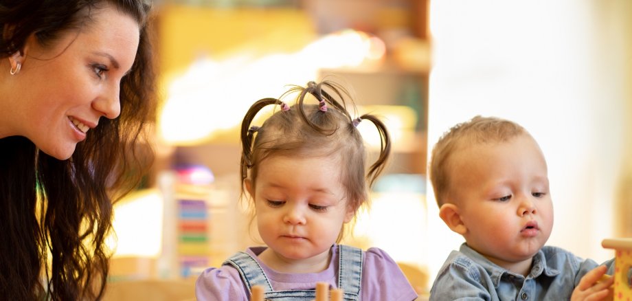 Teacher teaching kids play toy in classroom. Kindergarten pre school concept