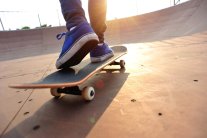 Skater auf einem Board skatet in Richtung Sonnenuntergang
