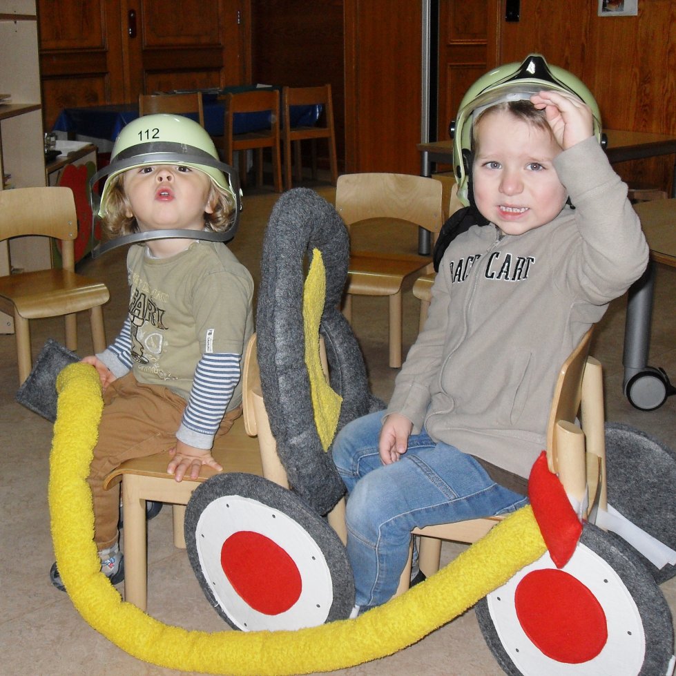 Zwei Kita-Kinder als Feuerwehrleute verkleidet