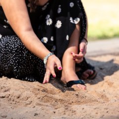 Kita-Betreuerin spielt mit Sand