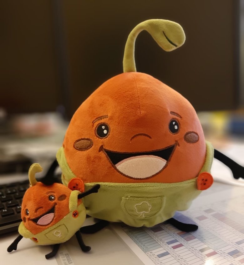 Ein kleines und ein großes Linsi-Maskottchen auf einem Schreibtisch