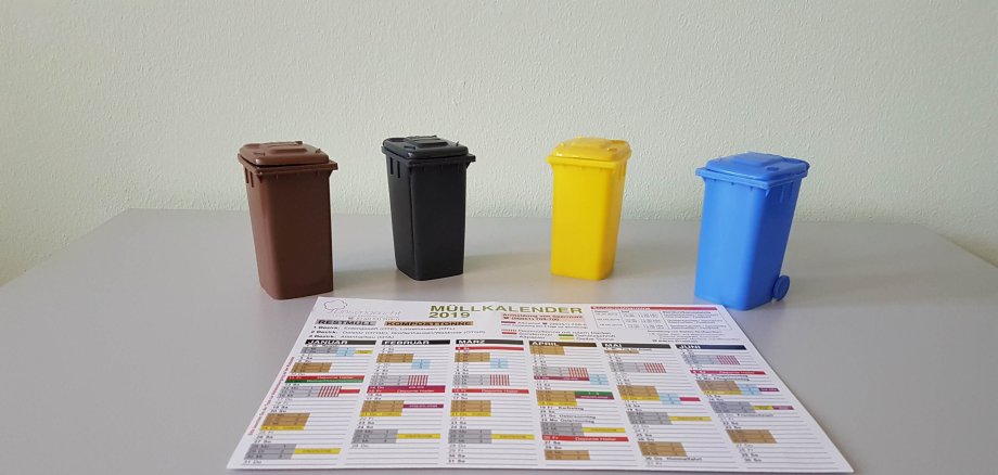 Abfallkalender vor Miniaturtonnen