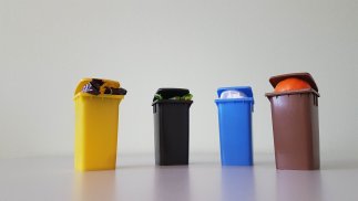 Gefüllte Miniaturabfalltonnen frontal fotografiert