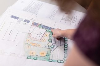 Finger deutet auf einen Planentwurf