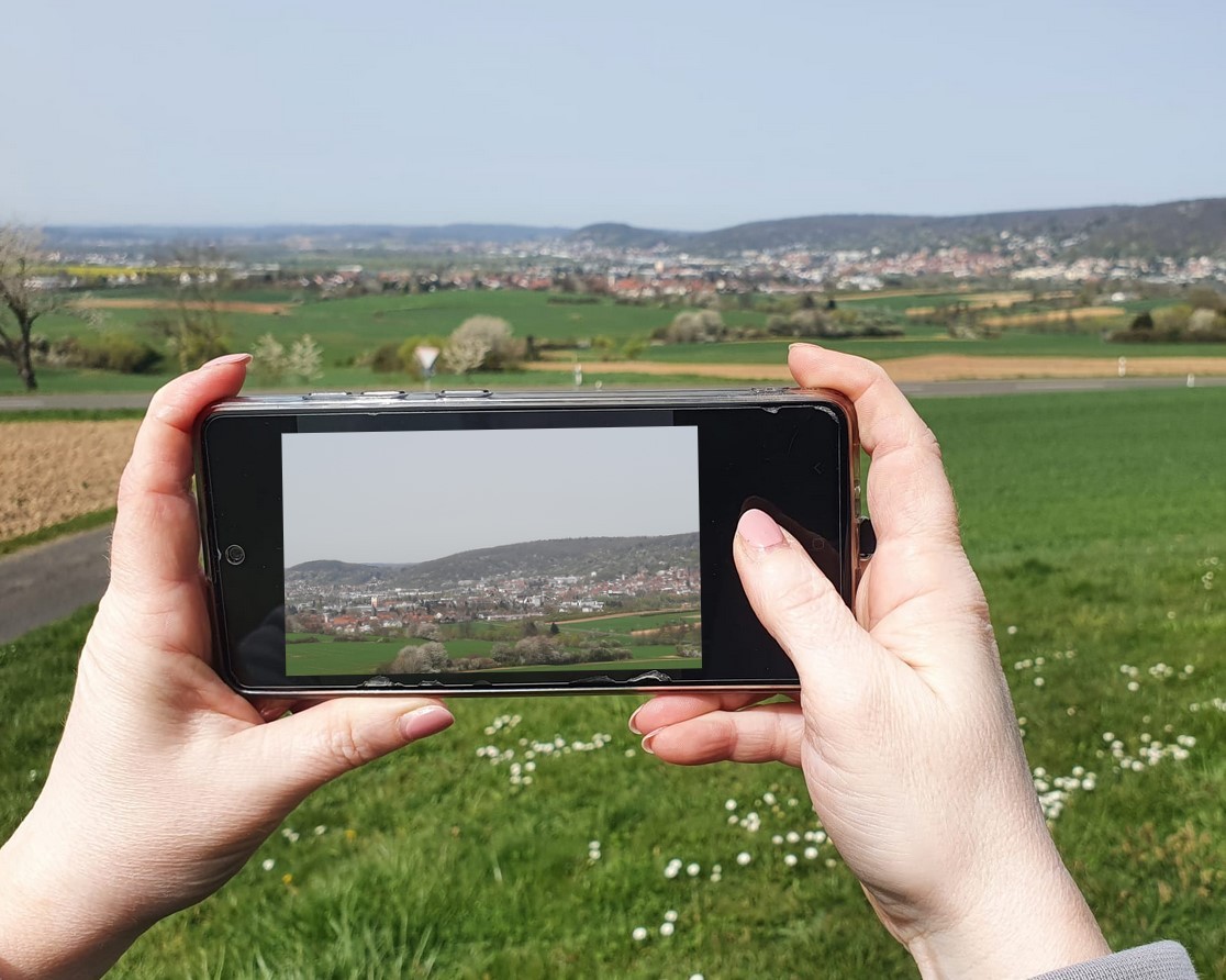 Mit der Kamerafunktion des Handys wird eine Landschaftsaufnahme getätigt