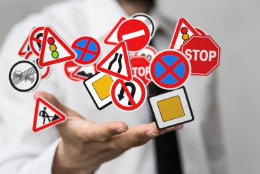 Verkehrsschilder die oberhalb einer Hand schweben