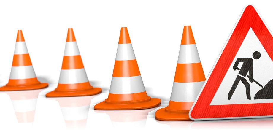 Mehrere Pylone sowie ein Baustellen-Schild als Symbolbild für eine Baustelle