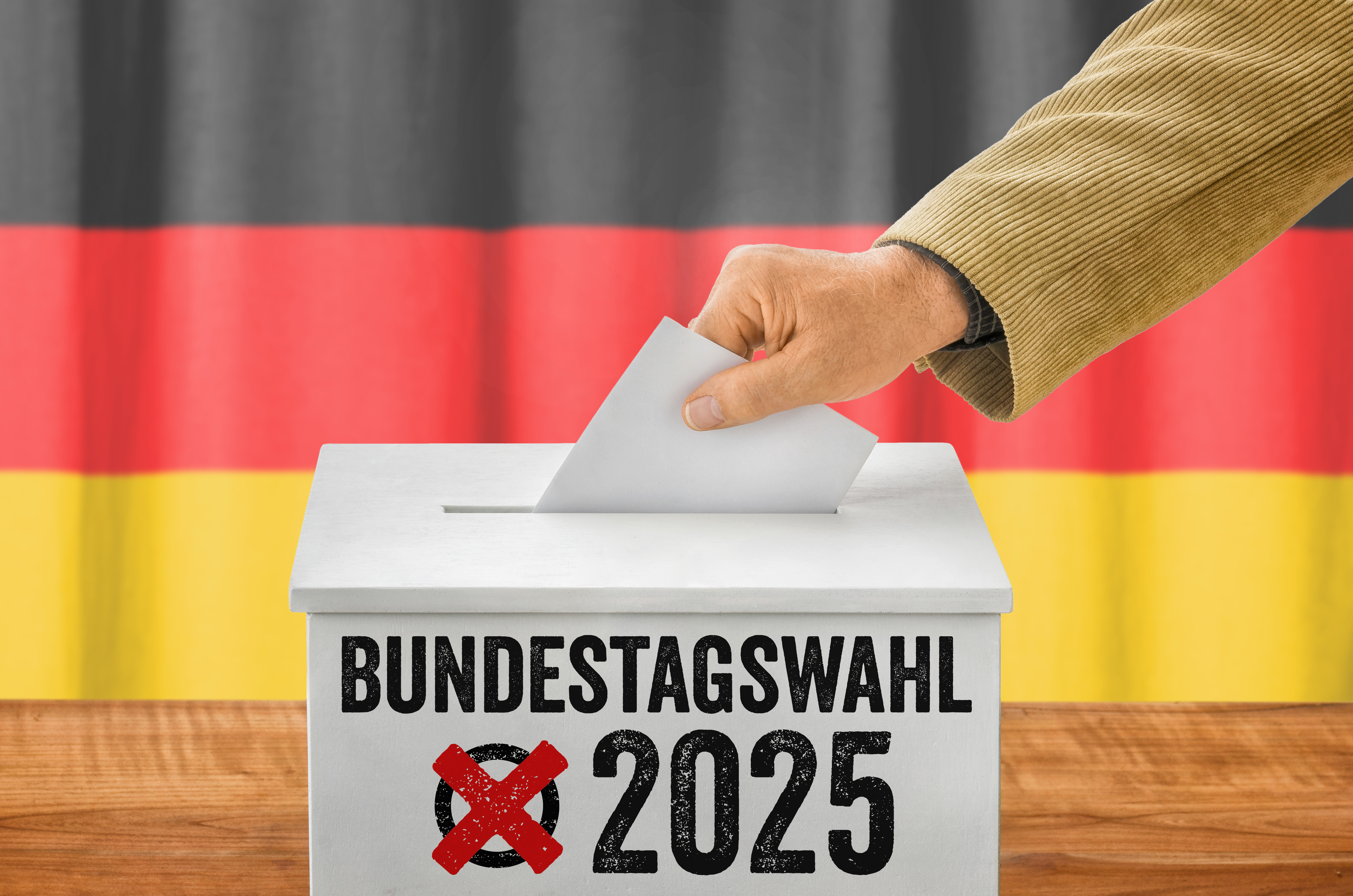 Mann wirft einen Stimmzettel in Wahlurne - Bundestagswahl 2025