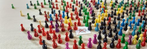 Viele bunte Spielfiguren stehen sybolisch für die heterogene Wahlbevölkerung, die allsonntags ihr Kreuzchen macht
