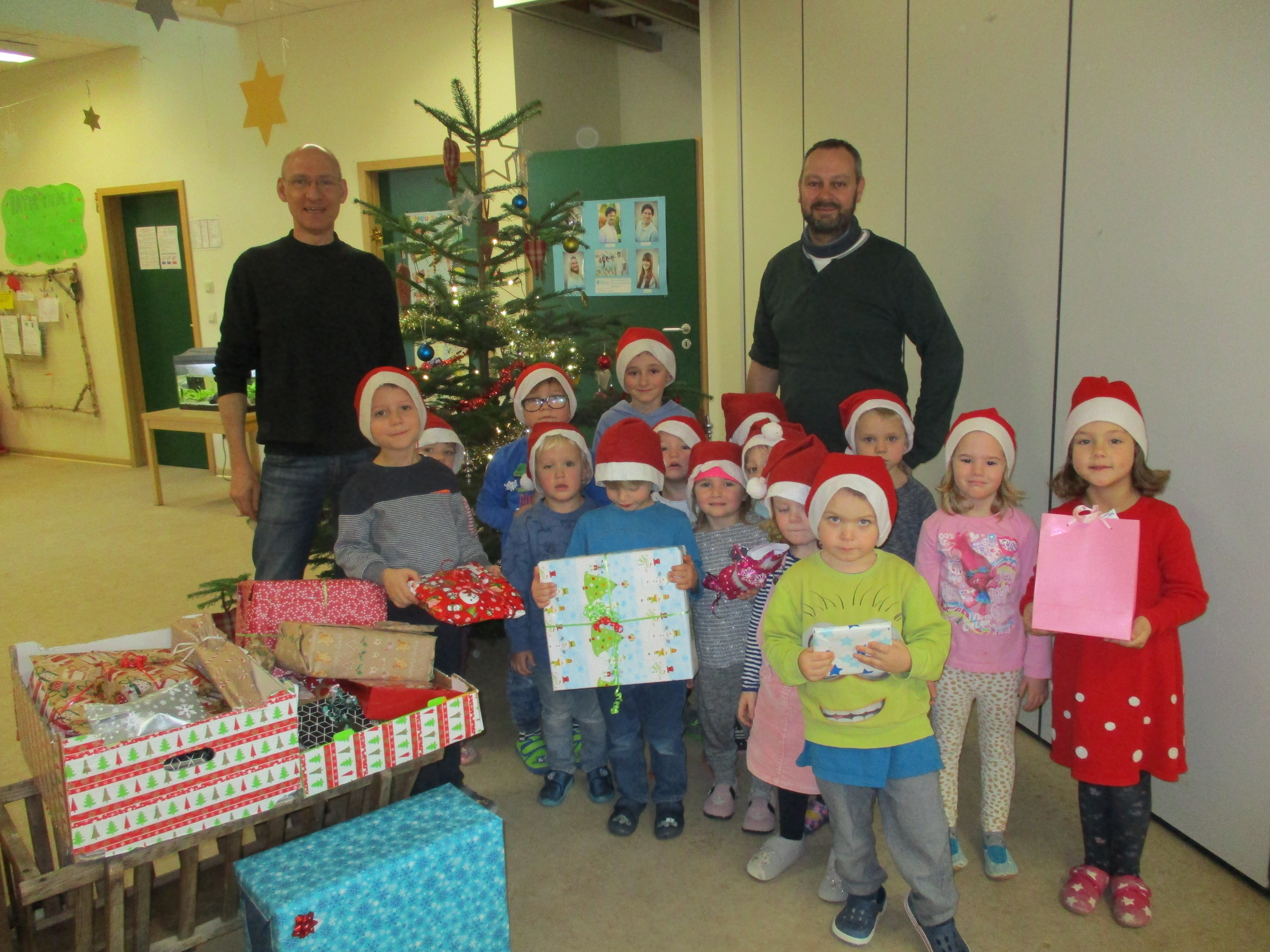 Kinder der Kindertagesstätte Wirbelwinde halten Weihnachtpäckchen in den Händen