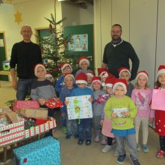 Kinder der Kindertagesstätte Wirbelwinde halten Weihnachtpäckchen in den Händen