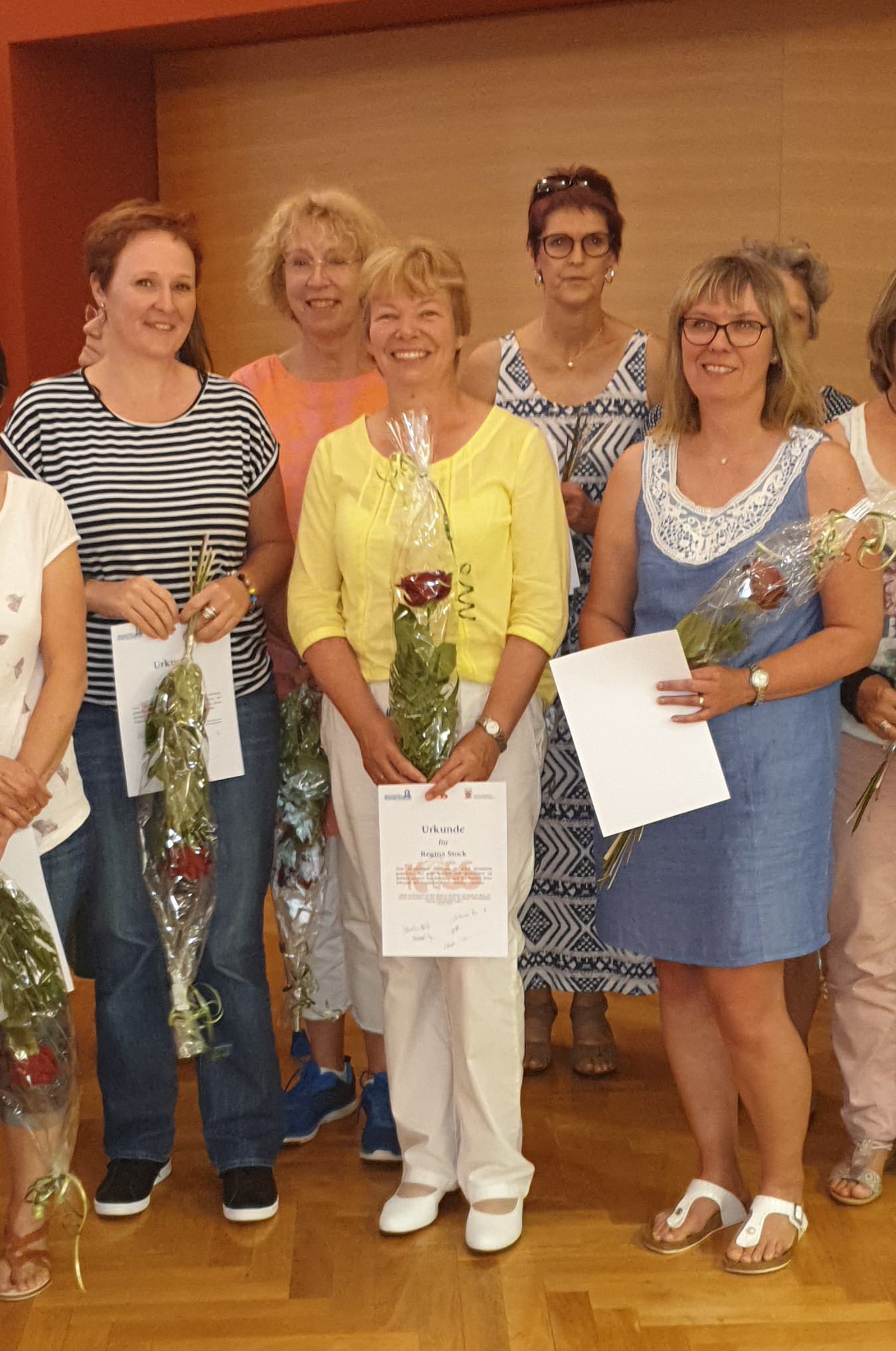 Mitarbeiterinnen der Linsengerichter Kindertagesstätten halten Blumen und Urkunden in den Händen.