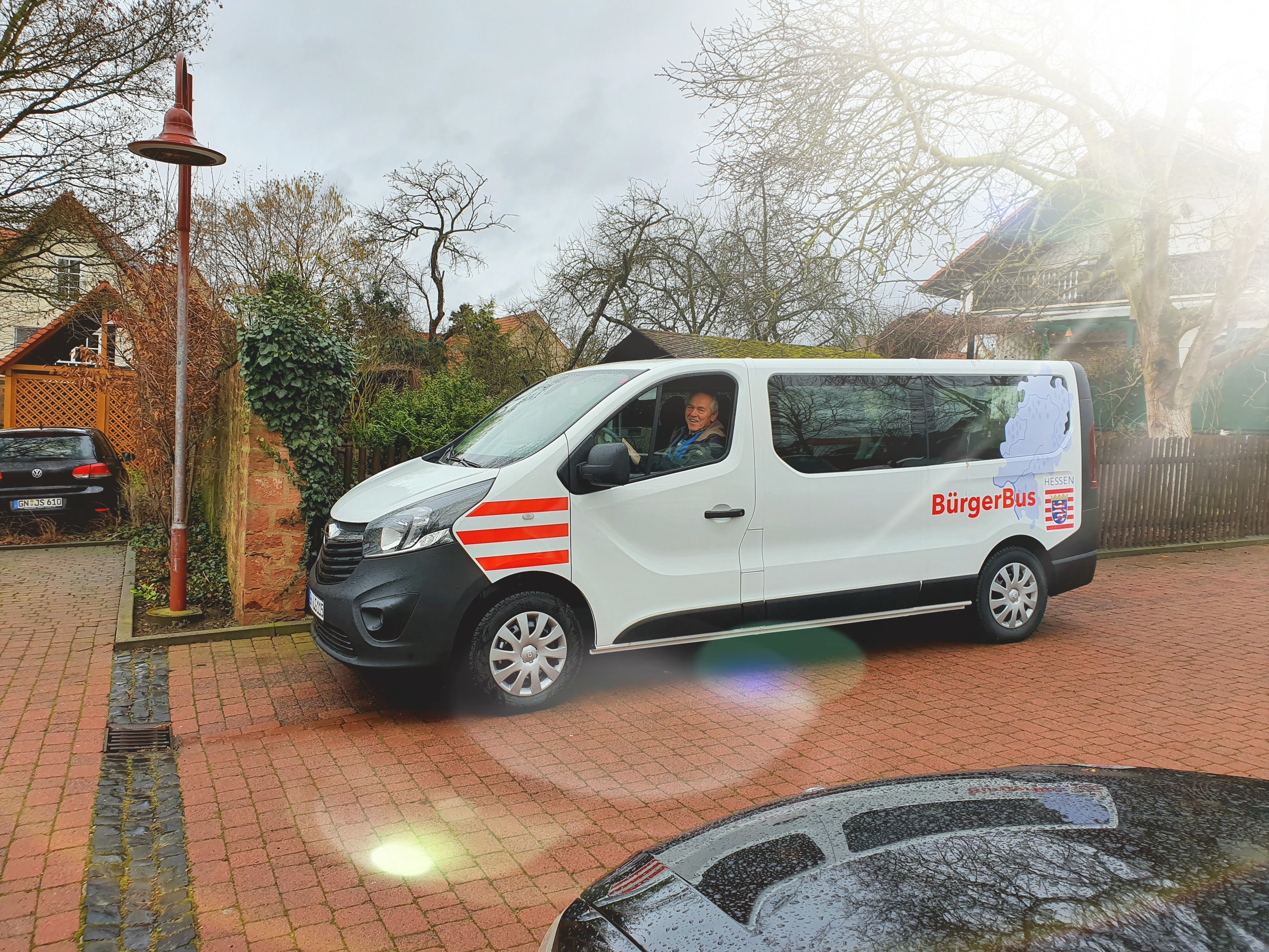 Bürgerbus der Gemeinde Linsengericht auf dem Parkplatz im Gegenlicht